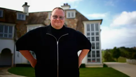 Getty Images Kim Dotcom stands outside his mansion in New Zealand