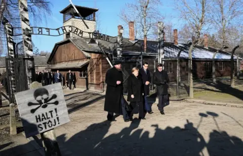 EPA German Chancellor Angela Merkel walks through the gates of the Auschwitz-Birkenau Memorial and Museum, accompanied by Polish Prime Minister Mateusz Morawiecki