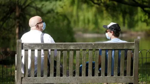 Reuters Two men wearing a protective face mask are seen in St James"s Park, as the spread of the coronavirus disease (COVID-19) continues, London,