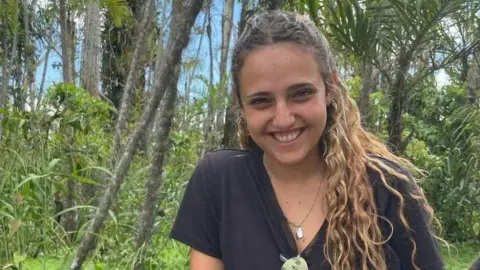 Reuters / Handout File image of Romi Gonen smiling at the camera. She has curly brown hair and is wearing a black top