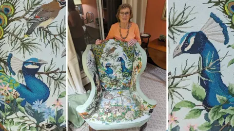 John Armitage Nanny Pat with the chair that has propelled her to fame - it is an armchair with wildlife including peacocks and other birds and animals depicted on it.