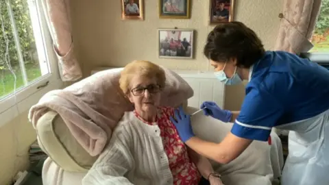 Alex Dunlop/BBC Nurse Laura Button giving booster