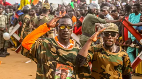 Mahamadou Hamidou/Reuters Coup supporters saluting outside a French military base in Niamey, Niger - Friday 11 August 2023