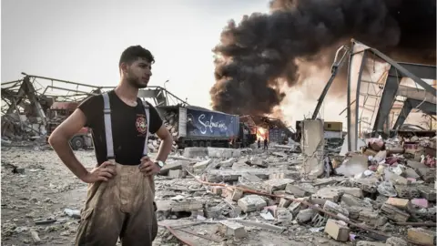 Getty Images Rescue worker stands amid debris in aftermath of blast