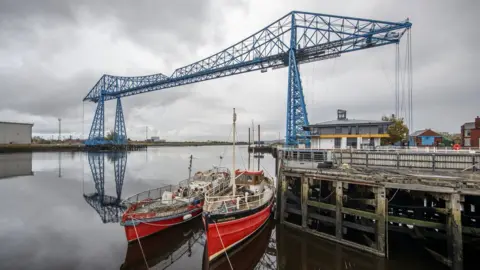 PA Media The Transporter Bridge and some fishing boats