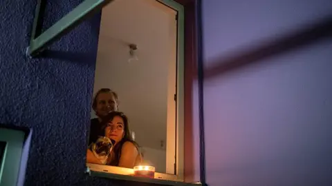 A couple watch a film from a window