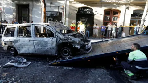 Reuters A worker removes a burned car after clashes of separatist demonstrators after a verdict in a trial over a banned independence referendum in Barcelona, Spain, October 17,