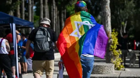 Getty Images A man carries a rainbow flag with the Star of David emblazoned on it