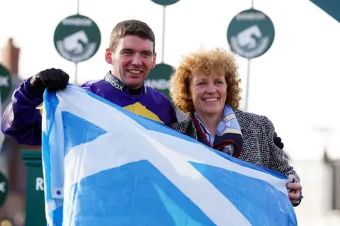 PA Media Derek Fox and Lucinda Russell celebrate after Corach Rambler's win in the Grand National