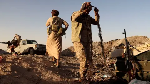 Reuters A Yemeni pro-government fighter holds a machine gun bullet belt at a frontline position during fighting against Houthi fighters in Marib, Yemen (16 March 2021)