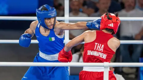 Aytac Unal / Getty Images An image of  Imane Khelif throwing a punch at Thailand's Janjaem Suwannapheng on 6 August 2024.