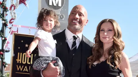 Getty Images Dwayne Johnson with partner Lauren Hashian and daughter Jasmine