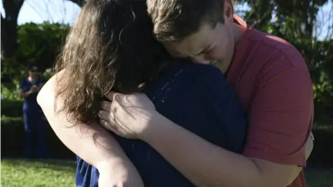 AFP/ GETTY IMAGES Students hugging and crying