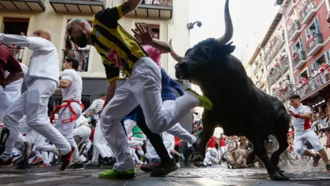 EPA Runners are chased by the bulls of Jose Escolar ranch during the second bull run of Sanfermines 2023 in Pamplona, northern Spain, 8 July 2023