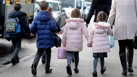 PA Media Children walking to school