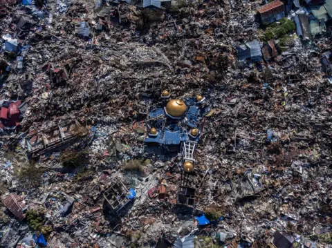 Reuters Aerial view of a collapsed mosque amid rubble in