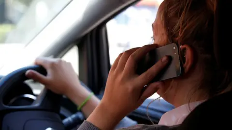 PA Woman using a mobile phone in the car