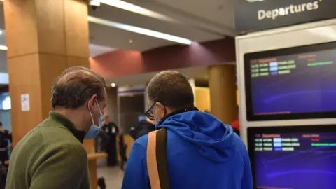 EPA Passengers check tickets at an airport