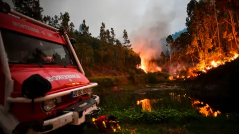 PATRICIA DE MELO MOREIRA/AFP/Getty Images Firefighter resting amid forest fire near Coimbra, June 2017