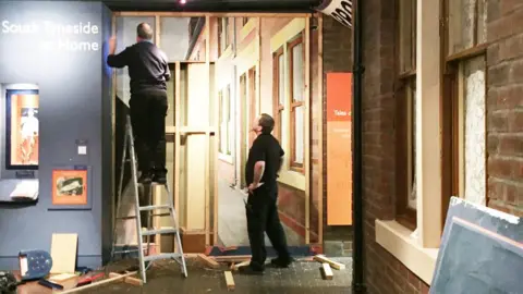 Sheila Graber Removing the boards covering the Jarrow March mural