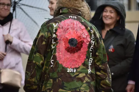 Getty Images A member of the public wears a jacket with a large poppy on the back