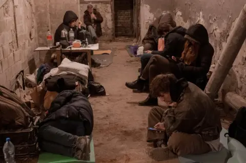 Reuters Kyiv residents take shelter in the basement of an apartment building (27 February 2022)