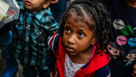 Getty Images Children wait for food in soup kitchens that provides free food in Caracas on 5 November 2017