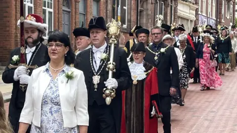 PA Media Civic dignitaries walking down a street in Rotherham's town centre