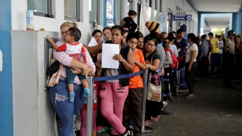 Reuters Venezuelans queue outside an immigration office in Tumbes, Peru