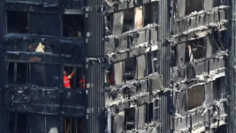 Reuters Members of the emergency services work inside burnt-out remains of Grenfell Tower