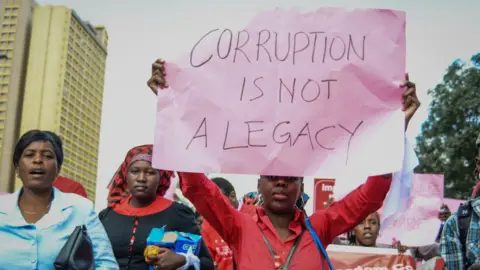 AFP A protestor carries a placard as Kenyans protested in the streets