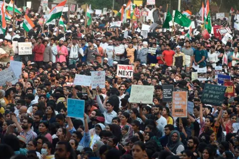 Getty Images Protesters hold placards during a demonstration against India's new citizenship law in Mumbai on December 19, 2019