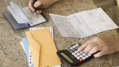 Getty Images Man calculating bills