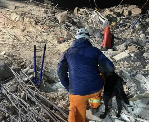 K9 Search & Rescue NI Ryan Gray and his dog searching a rubble pile for signs of life in Adana