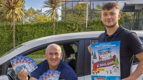 States of Guernsey Bill Cann and Callum Le Lacheur from Guernsey Post’s Lottery team with the new 2023 Christmas tickets