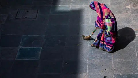 Getty Images An Indian woman sweeps her home