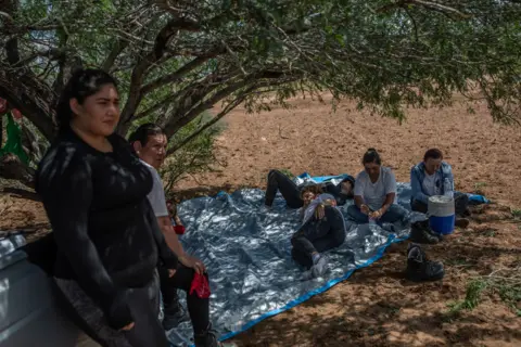 ALEJANDRO CEGARRA Searchers rest in the shadow of a tree