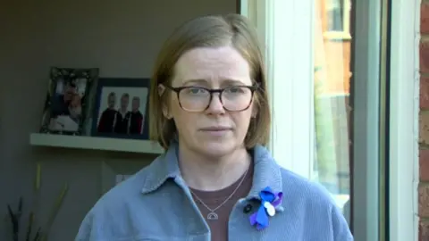 Rebecca Logan with pictures of her children behind her