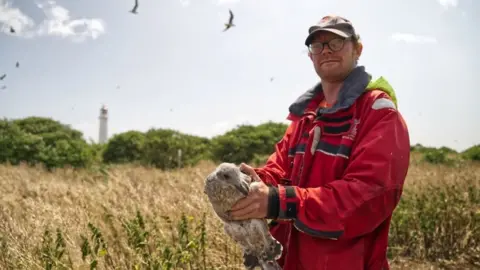 BBC Simon Parker holding a bird on Flat Holm