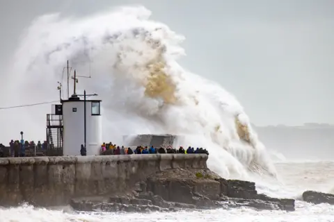 Getty Images Waves crash against the harbour wall on August 25, 2020 in Porthcawl, Wales. The Met Office have issued a yellow weather warning for wind and rain with gusts of 65mph possible inland and 70mph or more possible around coastal areas as Storm Francis passes over the UK. The storm is the second named storm in August and follows Storm Ellen last week