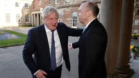 Reuters Former British Prime Minister Boris Johnson greets Northern Ireland Secretary Chris Heaton-Harris as he arrives at Hillsborough Castle for the Gala dinner to mark the 25th anniversary of the Good Friday Agreement, in Hillsborough, Northern Ireland, April 19, 2023.