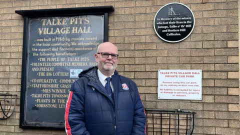 LDRS Man standing in front of a plaque