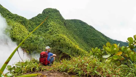 Max Stussi  A man on a green mountainside in Dominica
