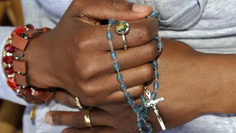 Getty Images Hands holding a crucifix