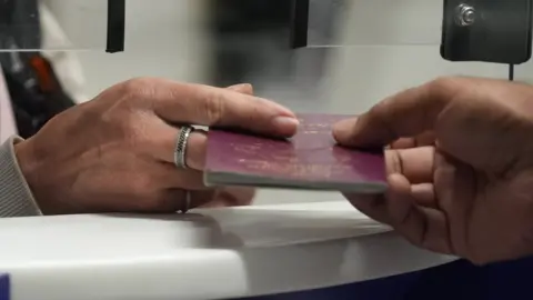 BBC Passport check at UK Border Force check-in desk at Gatwick Airport