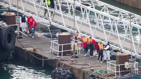 PA Media A group of people, thought to be migrants are brought into Dover by Border Force officers on Wednesday after crossing the English Channel.