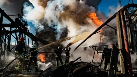 Getty Images Firefighters put out a blaze at a power station in Kyiv