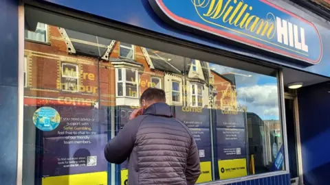 BBC "Matthew" outside William Hill on the phone