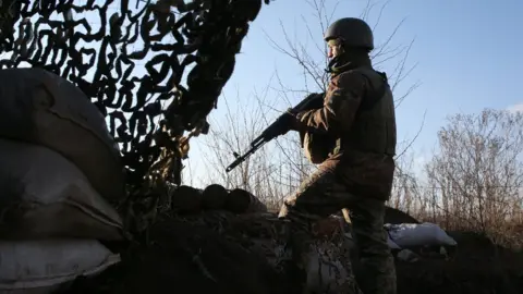 AFP A Ukrainian serviceman keeps watch at a position on the frontline with Russia-backed separatists not far from Gorlivka, Donetsk region