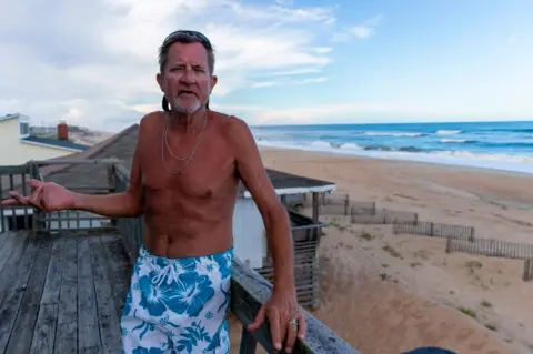 Getty Images A vacationer from Ohio tells Getty News he plans to ride out the storm from his rental condo at North Carolina's Outer Banks